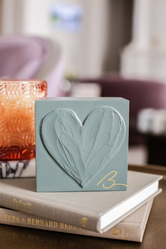 Aged Green hand painted heart block displayed on stacked books with lifestyle decor