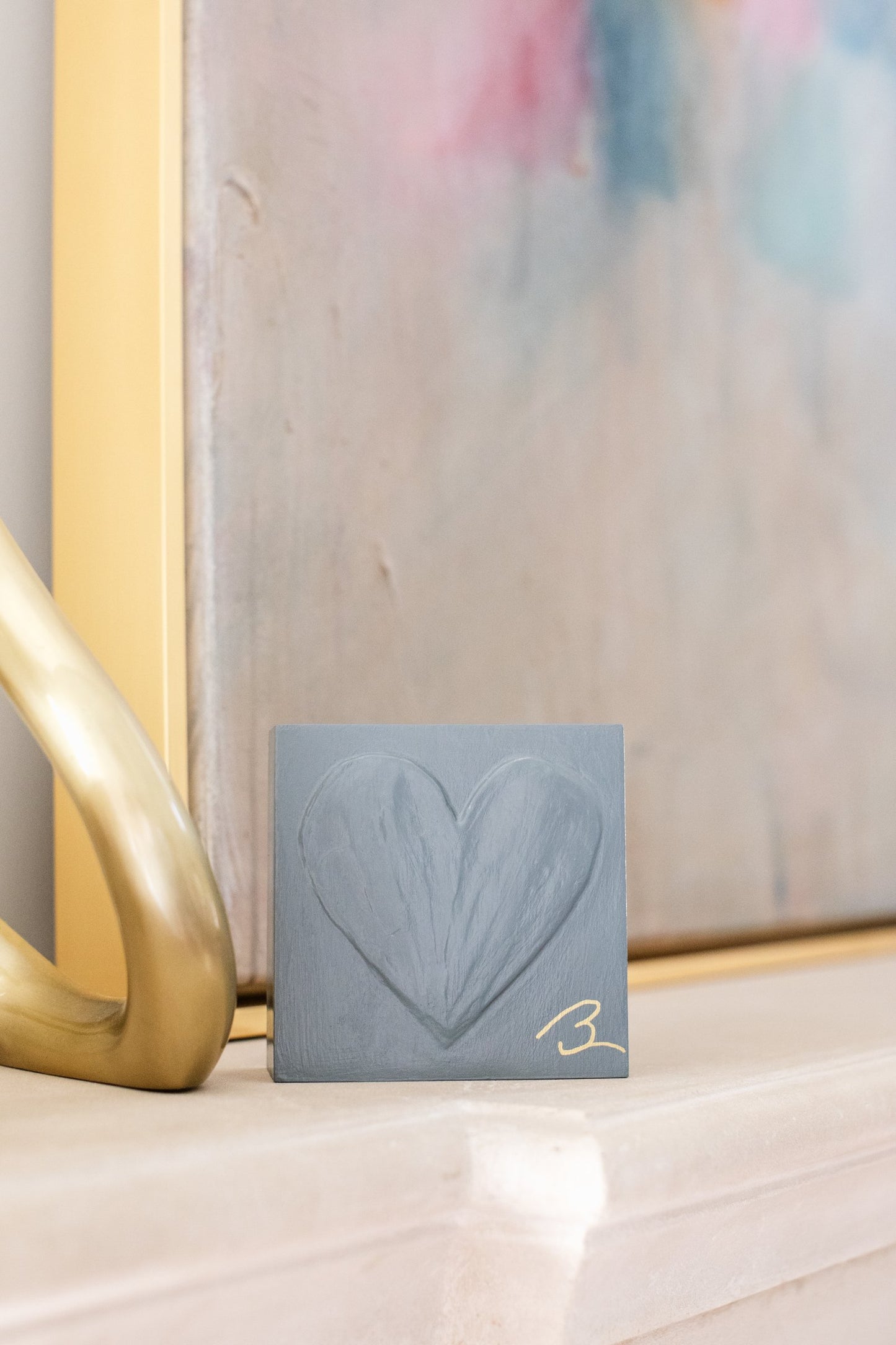 Grounded Blue heart sculpture held in hand showing 4-inch scale
