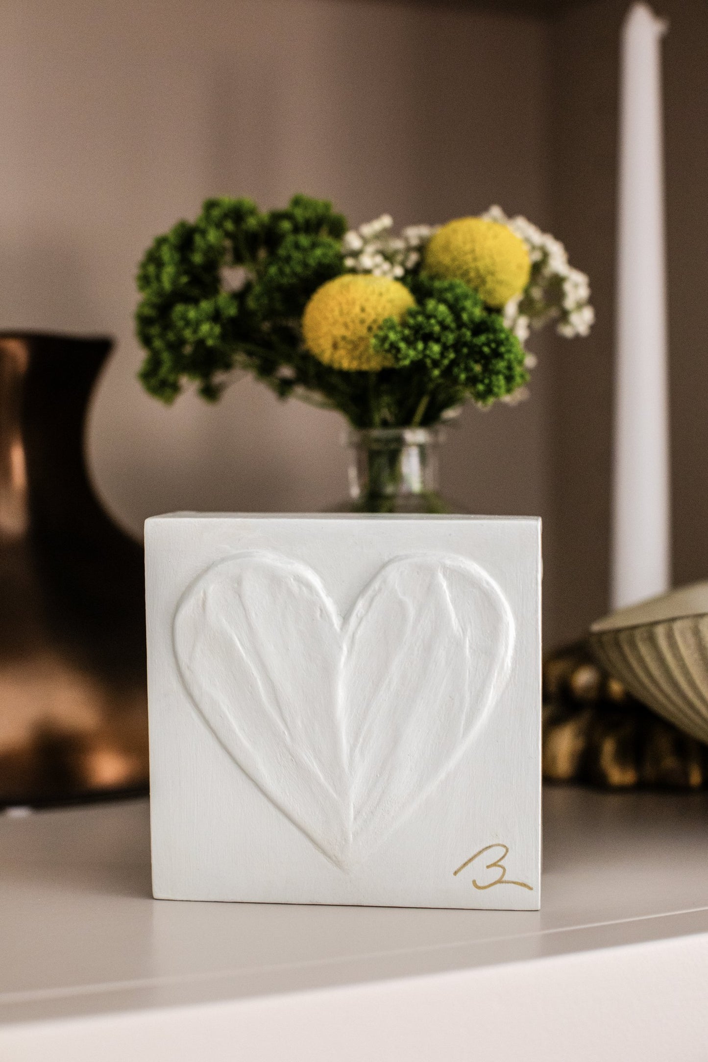 Sunlit White heart sculpture — close-up showing textured brushstrokes and shadows in warm white