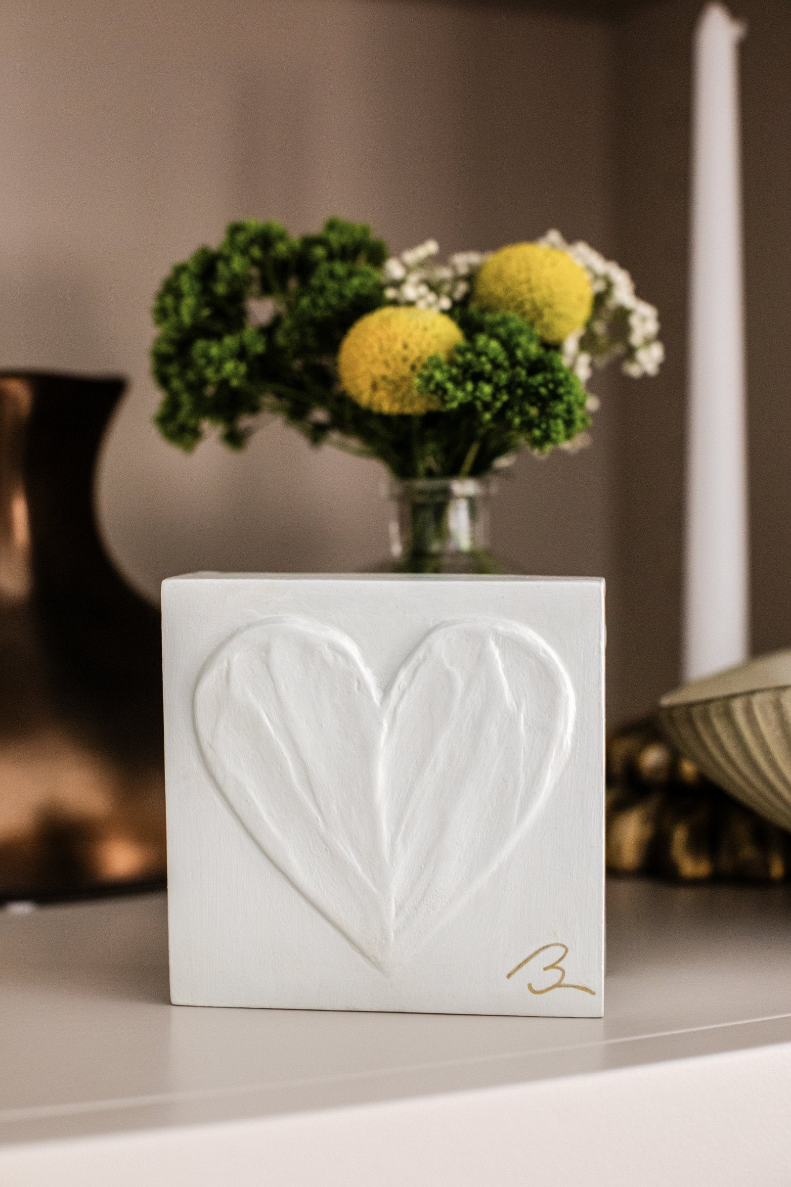 Sunlit White heart sculpture — close-up showing textured brushstrokes and shadows in warm white